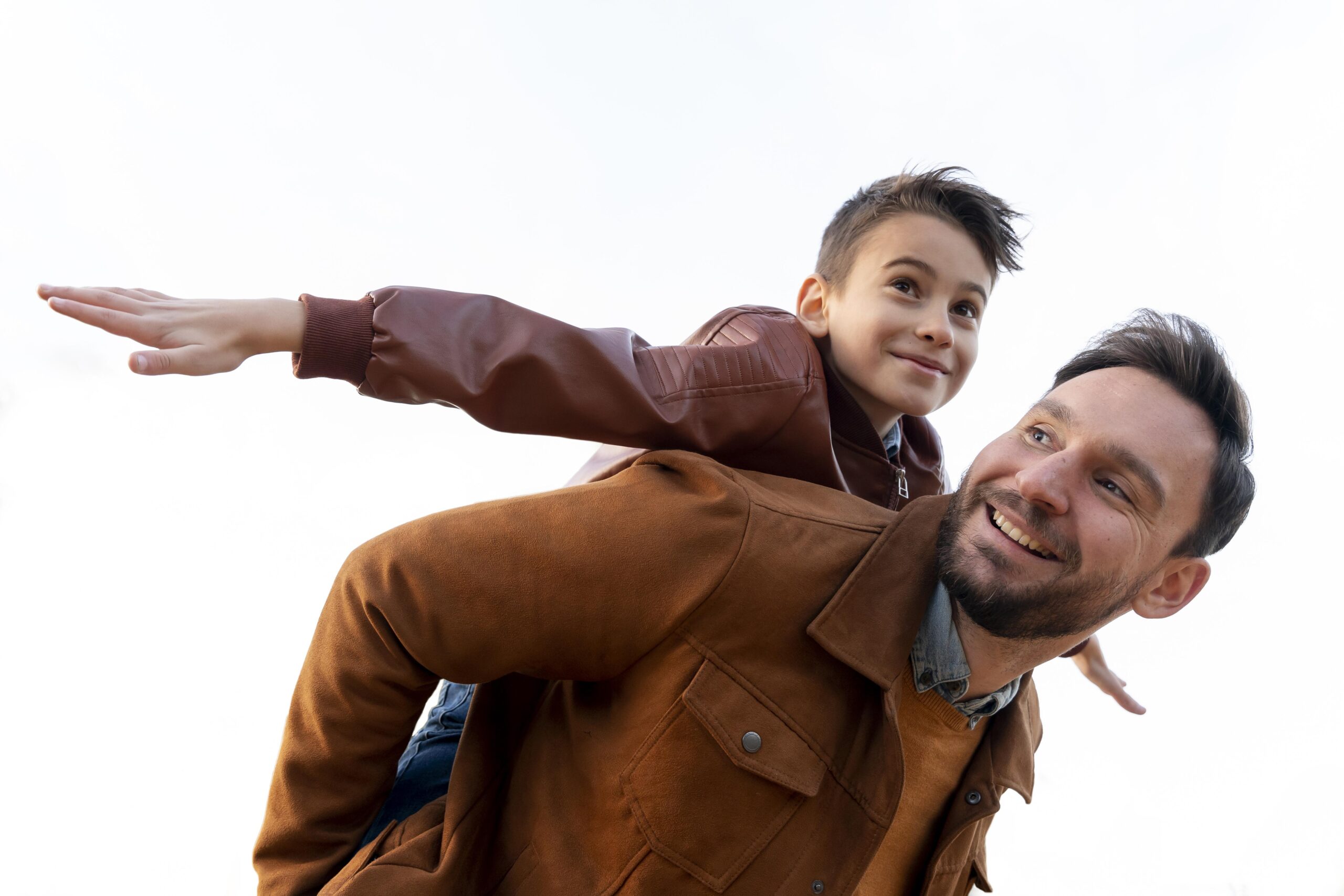 Pai e filho brincando ao ar livre, sorrisos e felicidade.