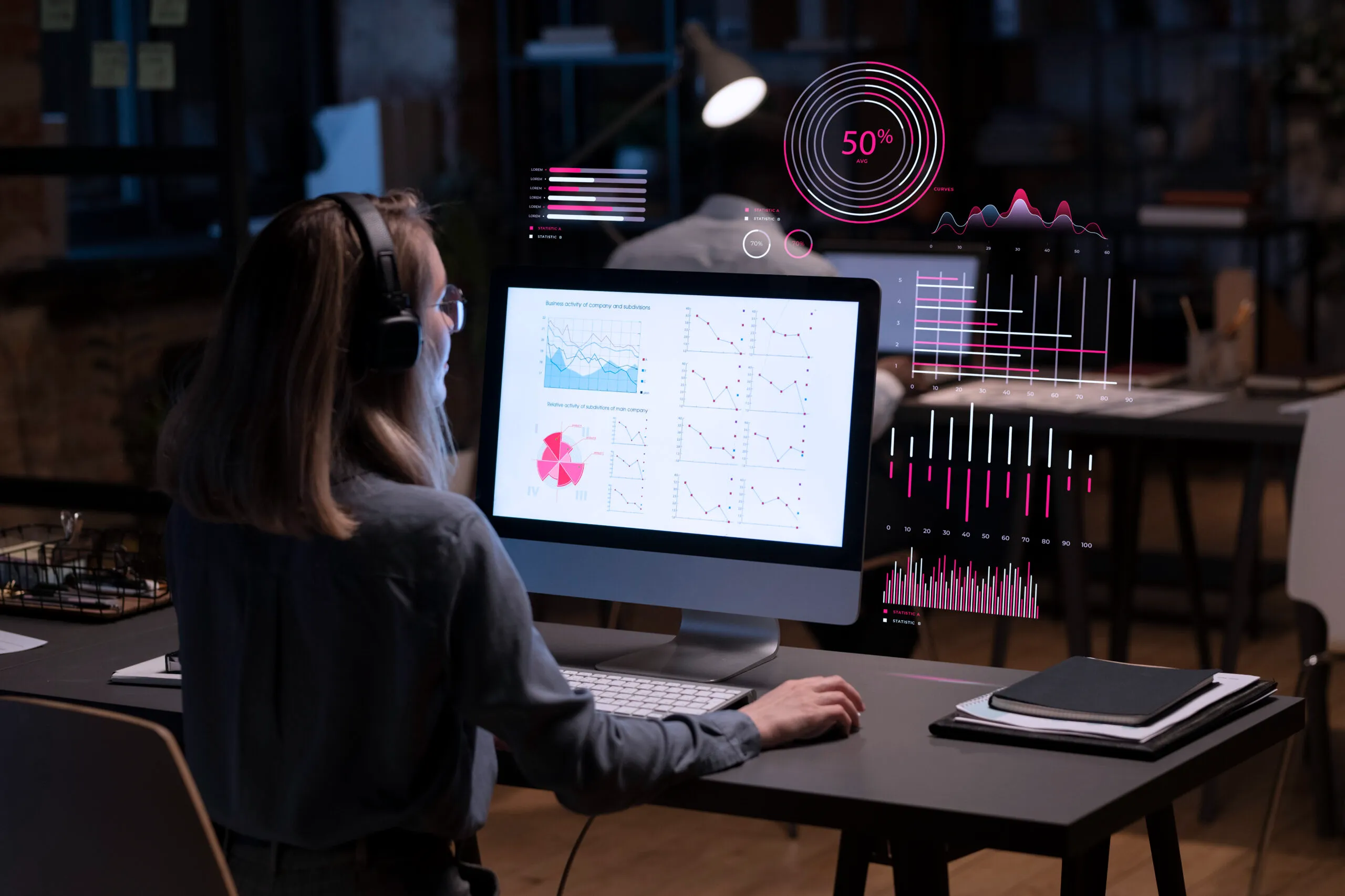 Mulher em escritório escuro analisa gráficos na tela do computador com interface digital futurista.