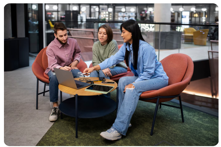 Algumas pessoas sentadas em cadeiras olhando para um notebook.