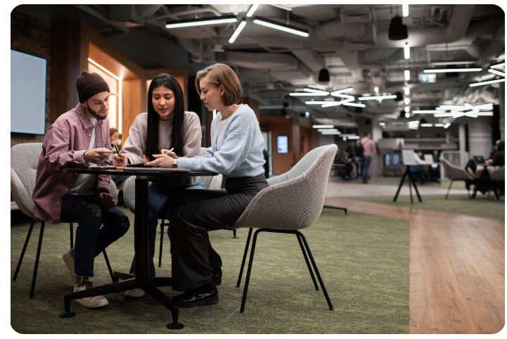 Três pessoas sentadas em uma mesa conversando.