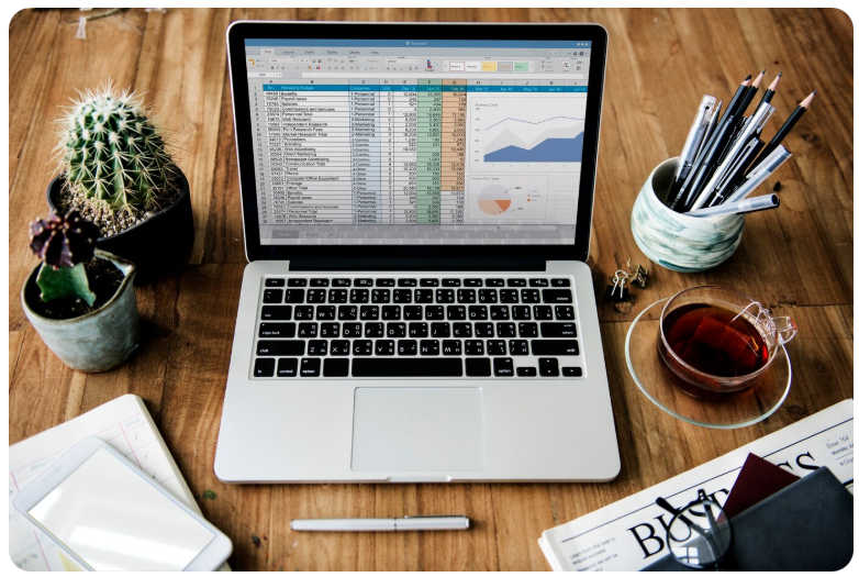 Notebook em uma mesa com alguns materiais de escritório.